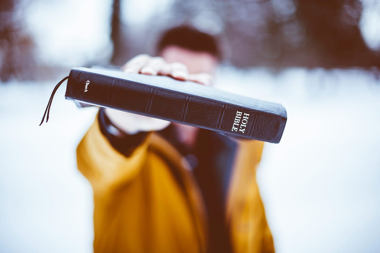 A group of people gathered around an open Bible, studying and discussing.